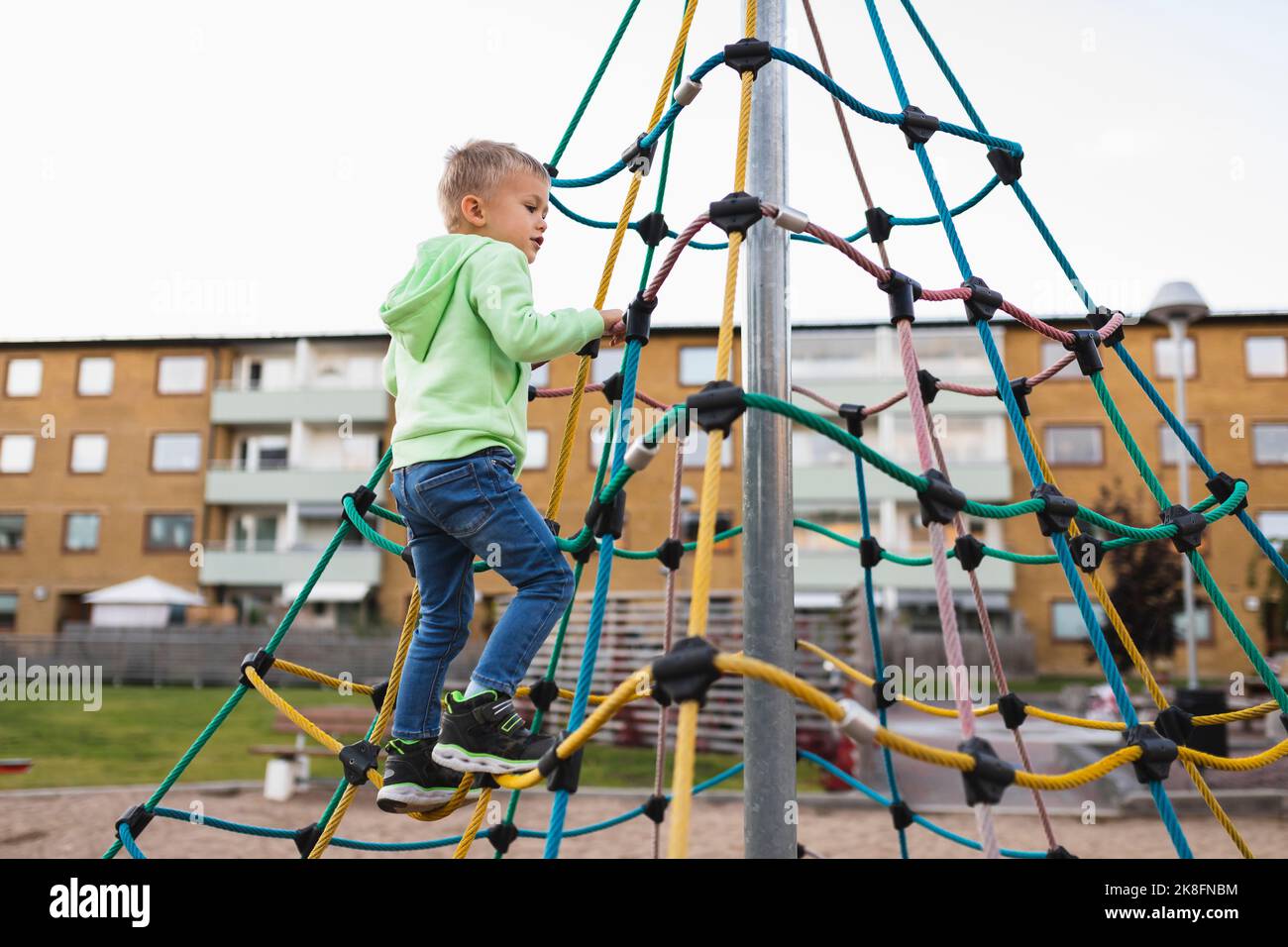 Boy climbing rope in park Stock Photo