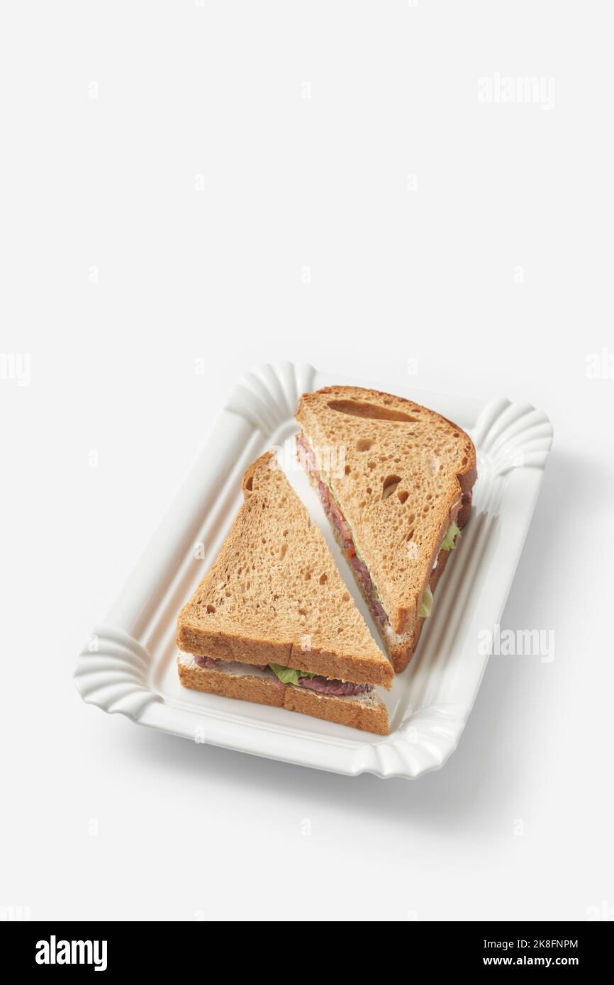 Brown bread ham sandwich on tray against white background Stock Photo