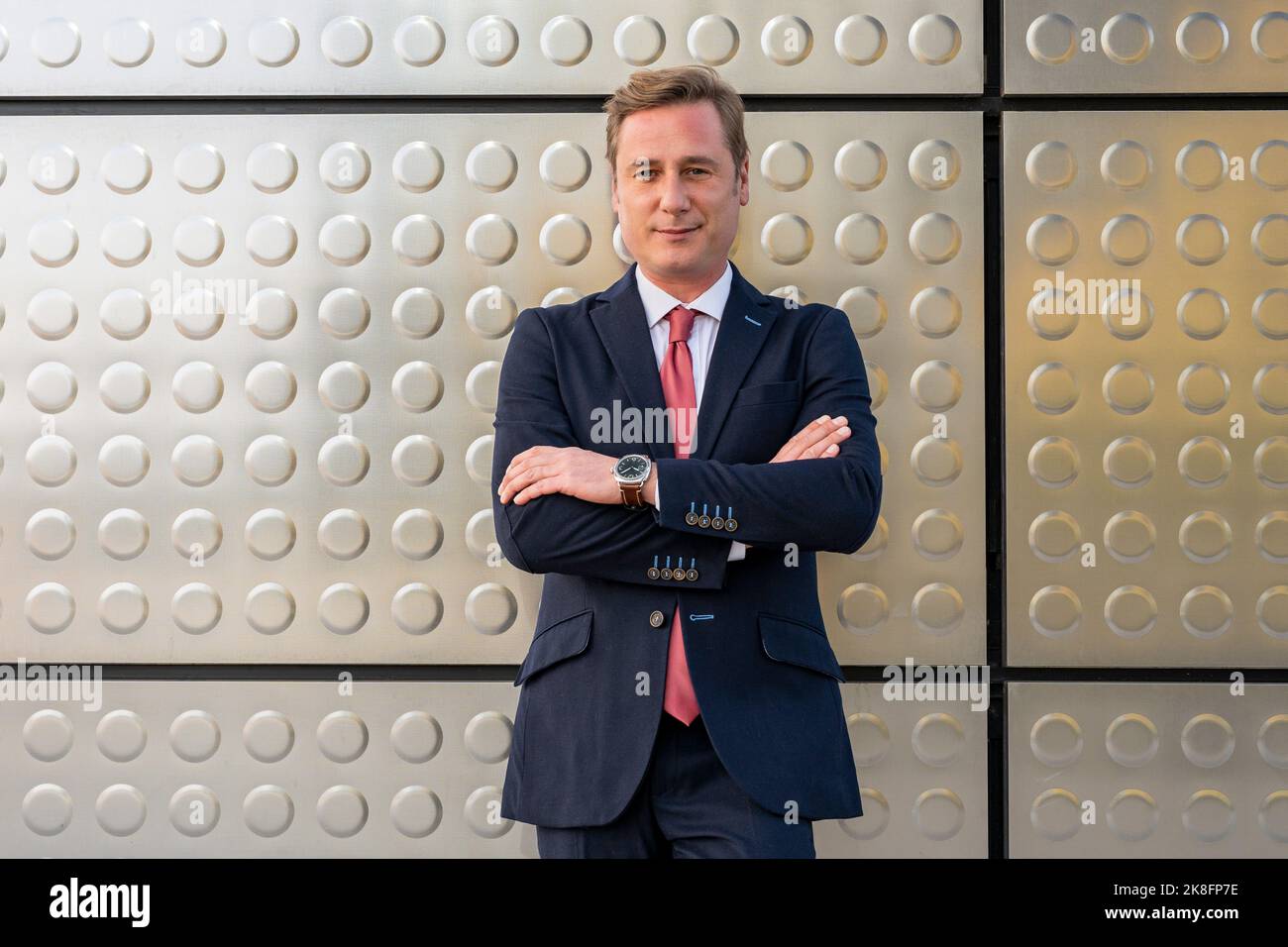 Mature businessman with arms crossed in front of metal wall Stock Photo ...