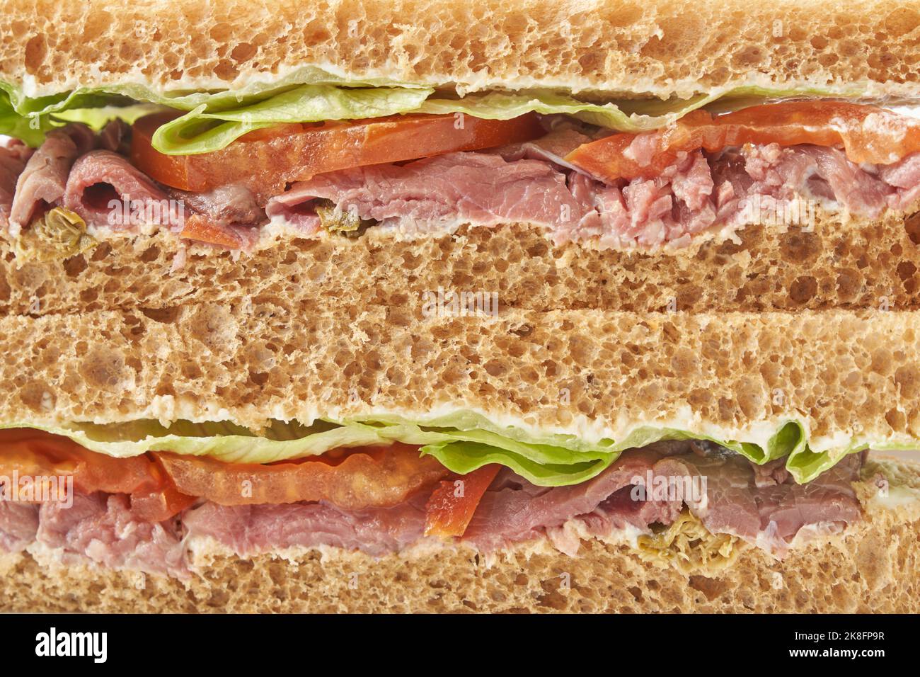 Delicious stuffed layer of ham and veggies in brown bread sandwich Stock Photo