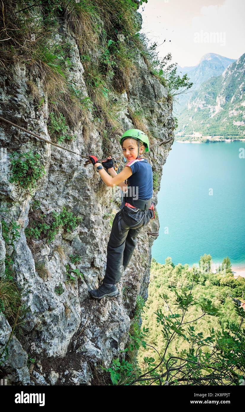Smiling girl climbing mountain near Lake Idro Stock Photo