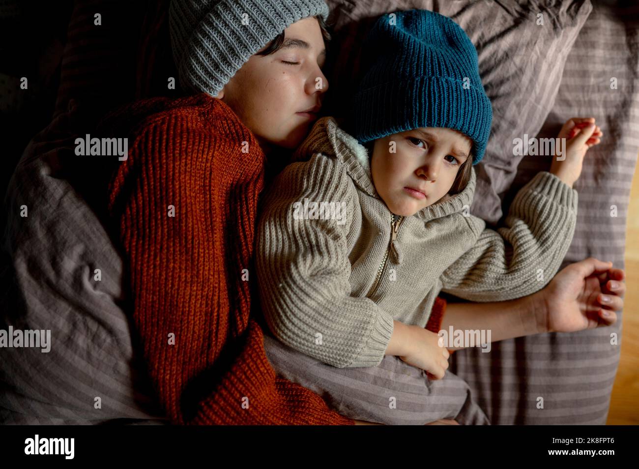 Boys in warm clothing sleeping on bed at bedroom Stock Photo Alamy