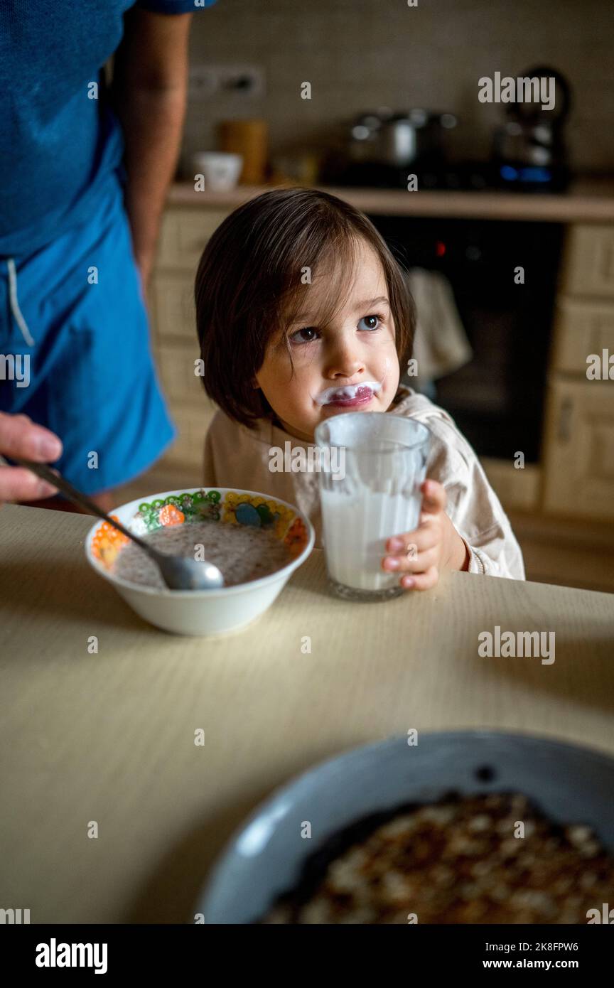 Son having breakfast by father on table at home Stock Photo