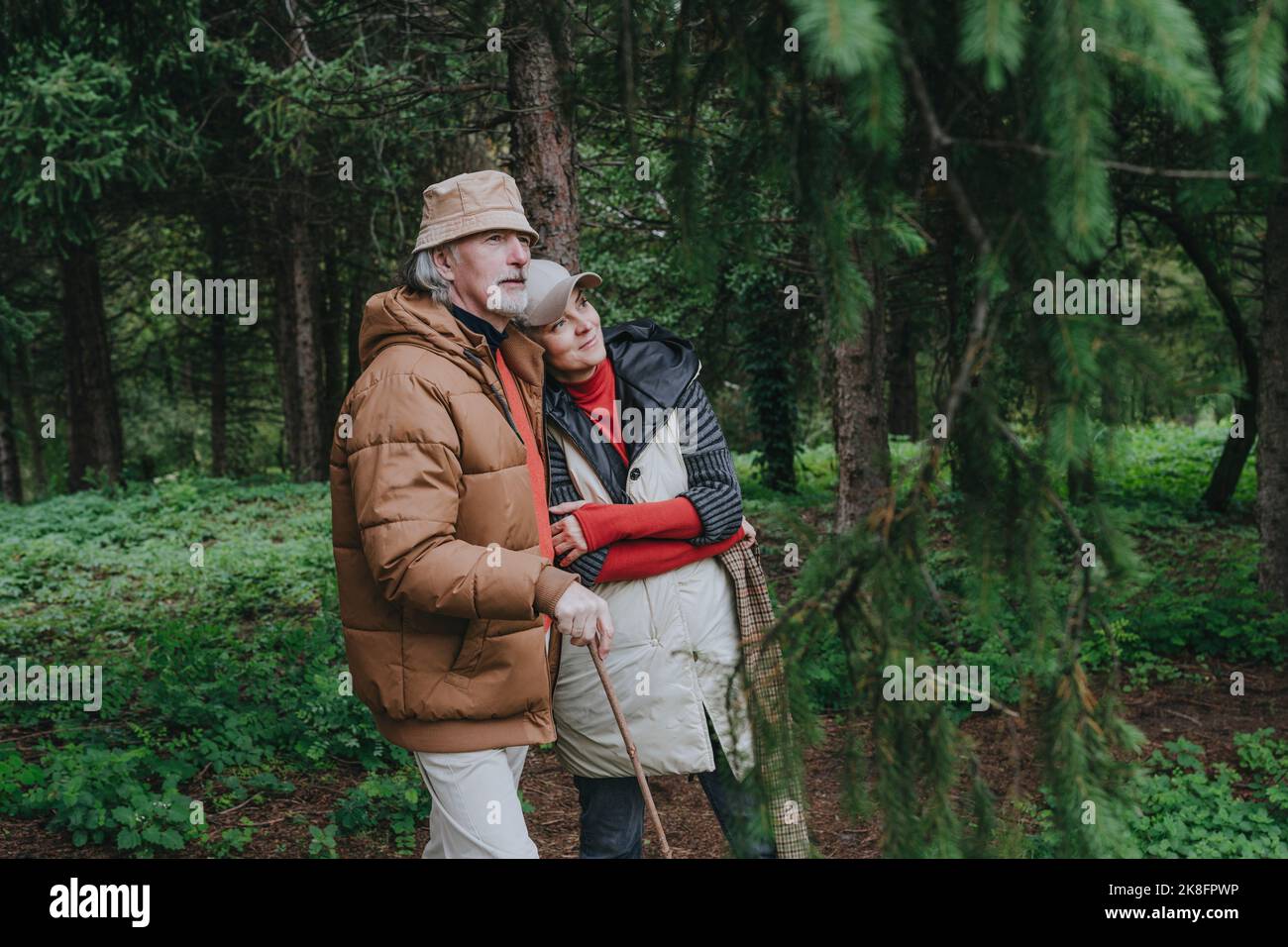 Thoughtful couple standing in forest Stock Photo