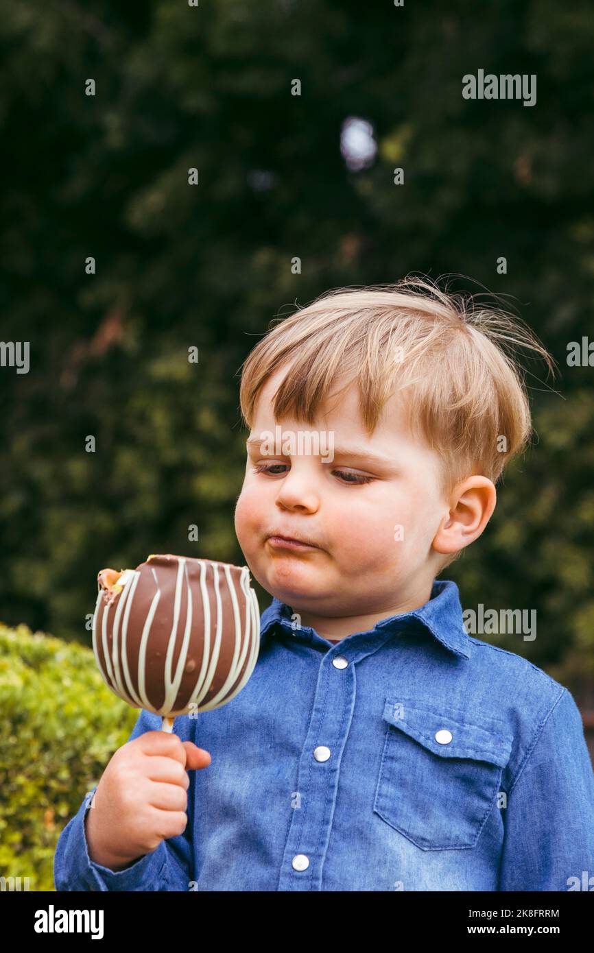 Cute boy with taffy apple at park Stock Photo