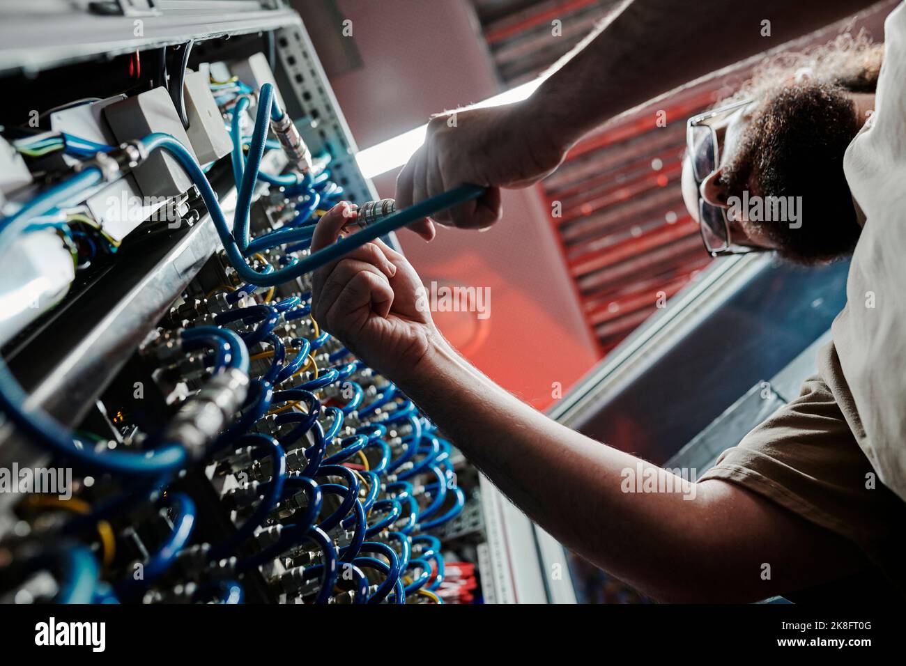 Technician connecting cables of server in data center Stock Photo