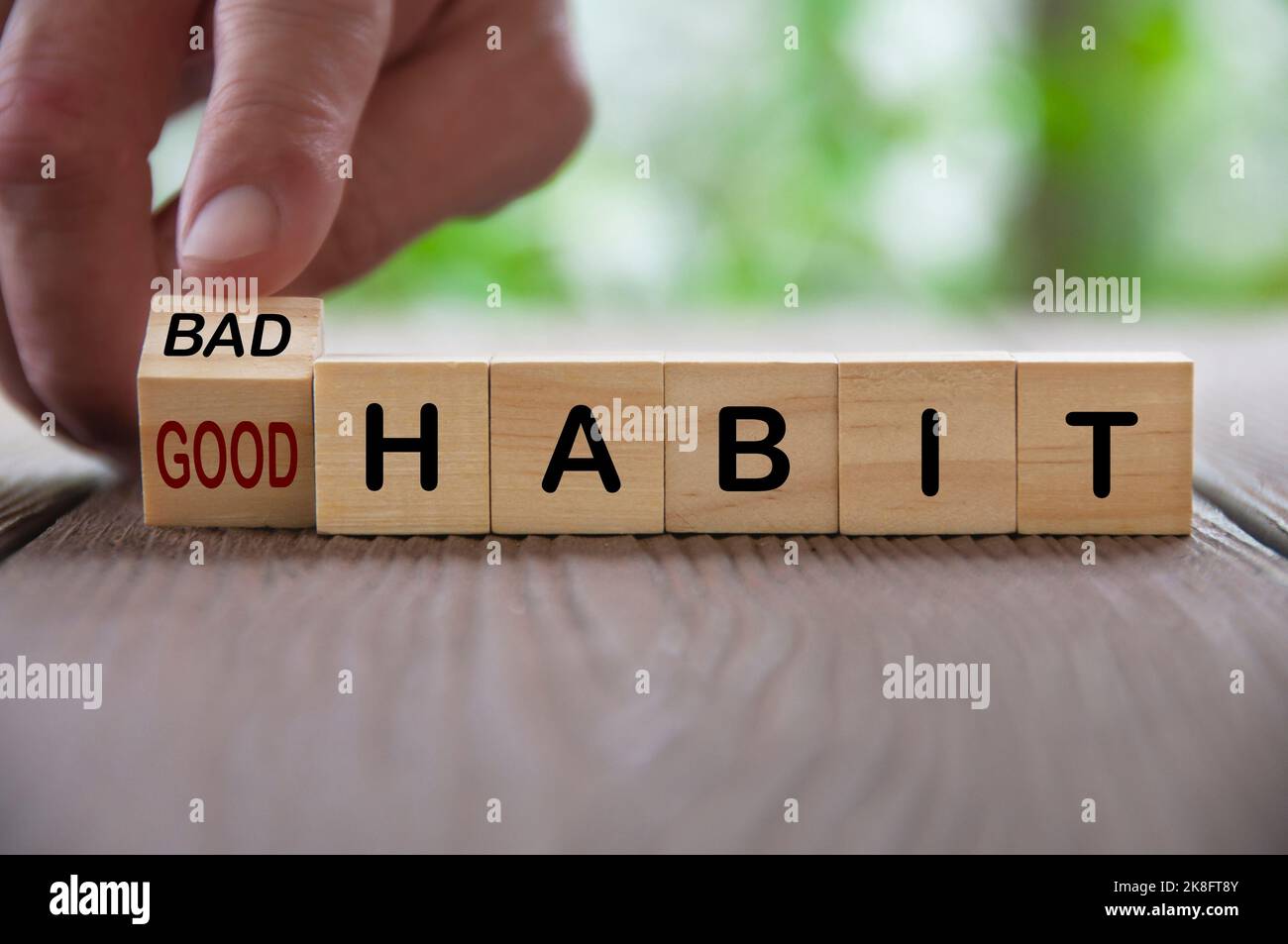 Finger turning bad and good text on wooden blocks. Good and bad habit concept. Stock Photo