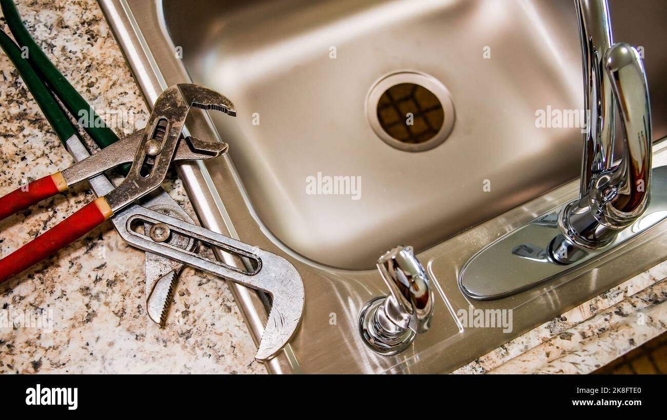 New kitchen sink with pipe wrench key on top from above Stock Photo Alamy
