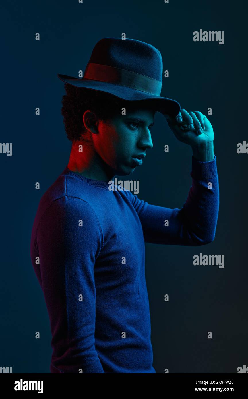 Stylish outlook man in hat on dark background Stock Photo - Alamy