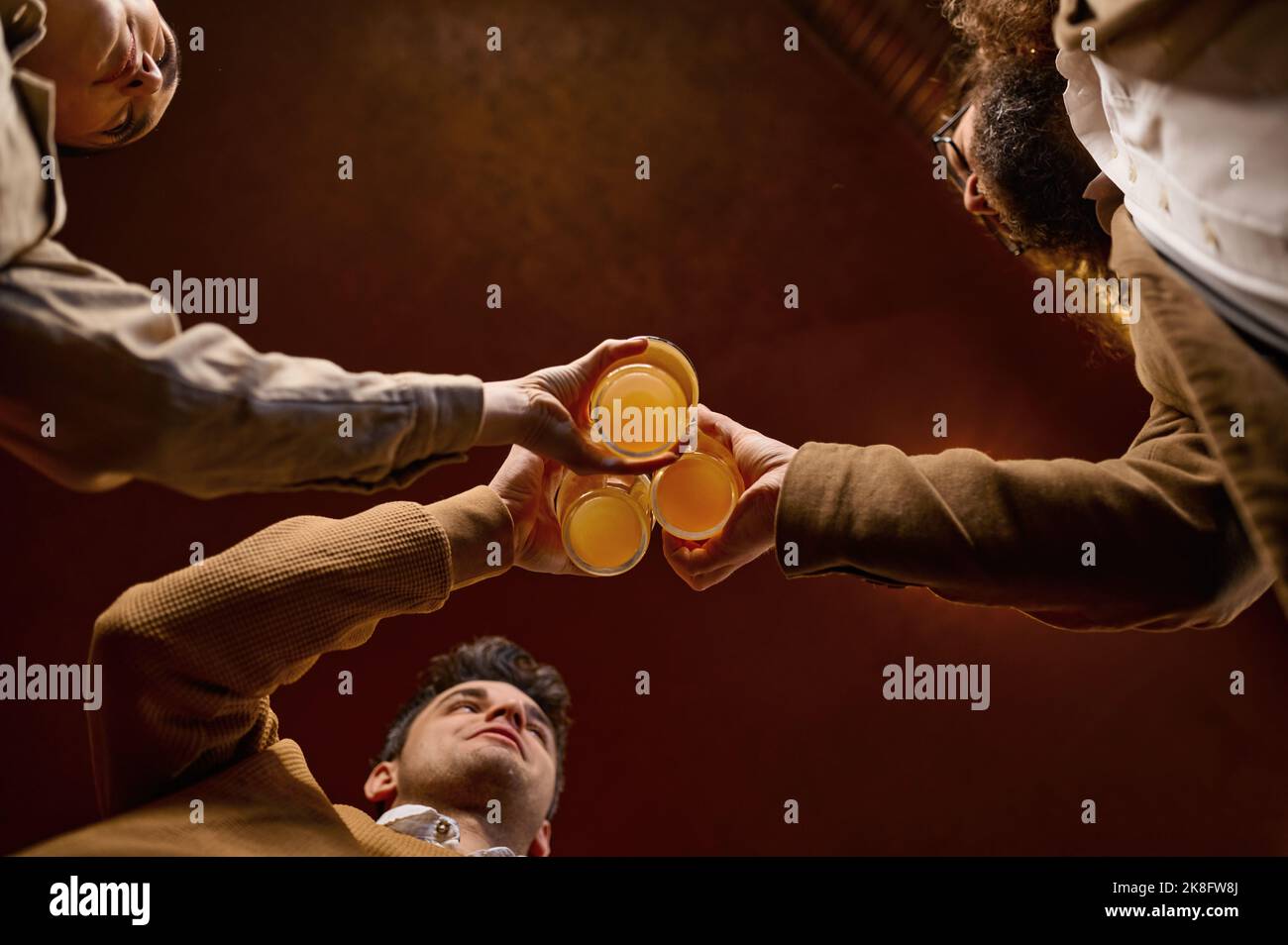 Bottom view of friends clinking beer mugs Stock Photo Alamy