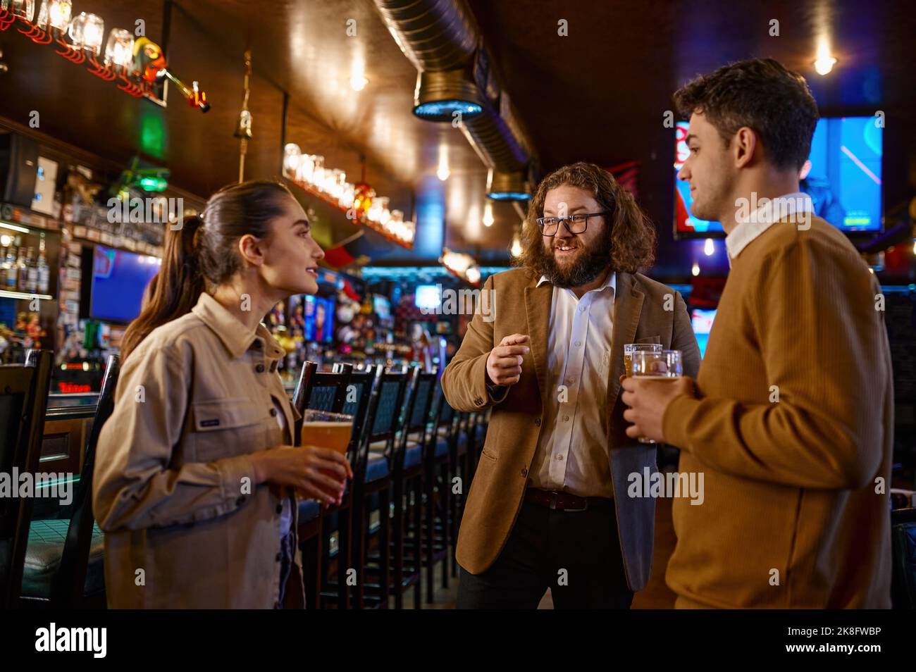 Cheerful friends talking drinking draft beer in pub Stock Photo