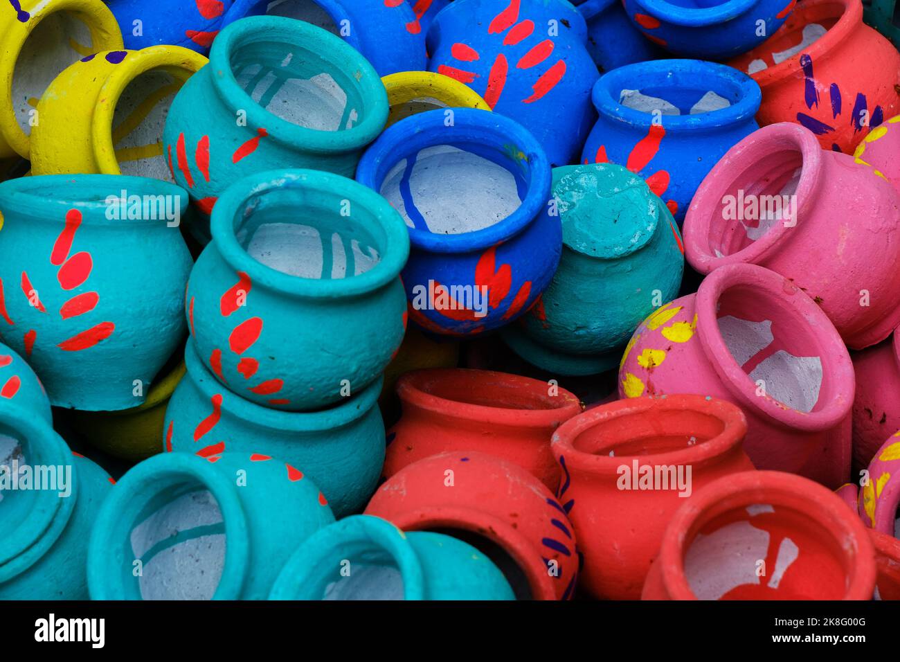 Artisan painting earthen pots, A background of colorful pots used for