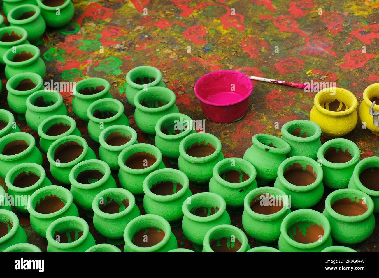 Artisan painting earthen pots, A background of colorful pots used for