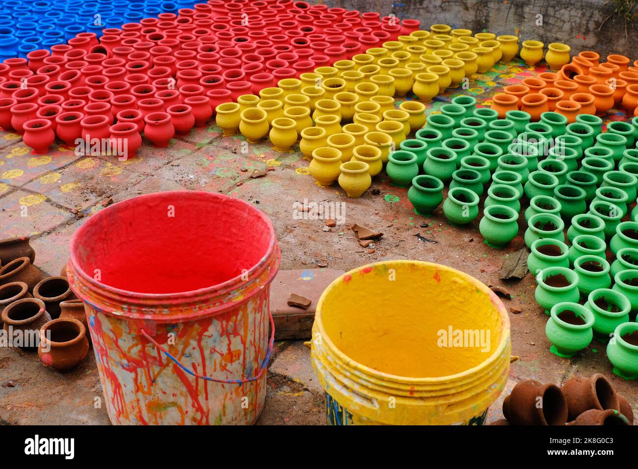 Artisan painting earthen pots, A background of colorful pots used for