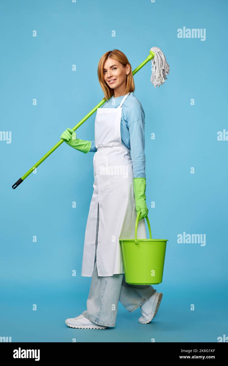 woman in green rubber gloves holding mop and bucket Stock Photo Alamy