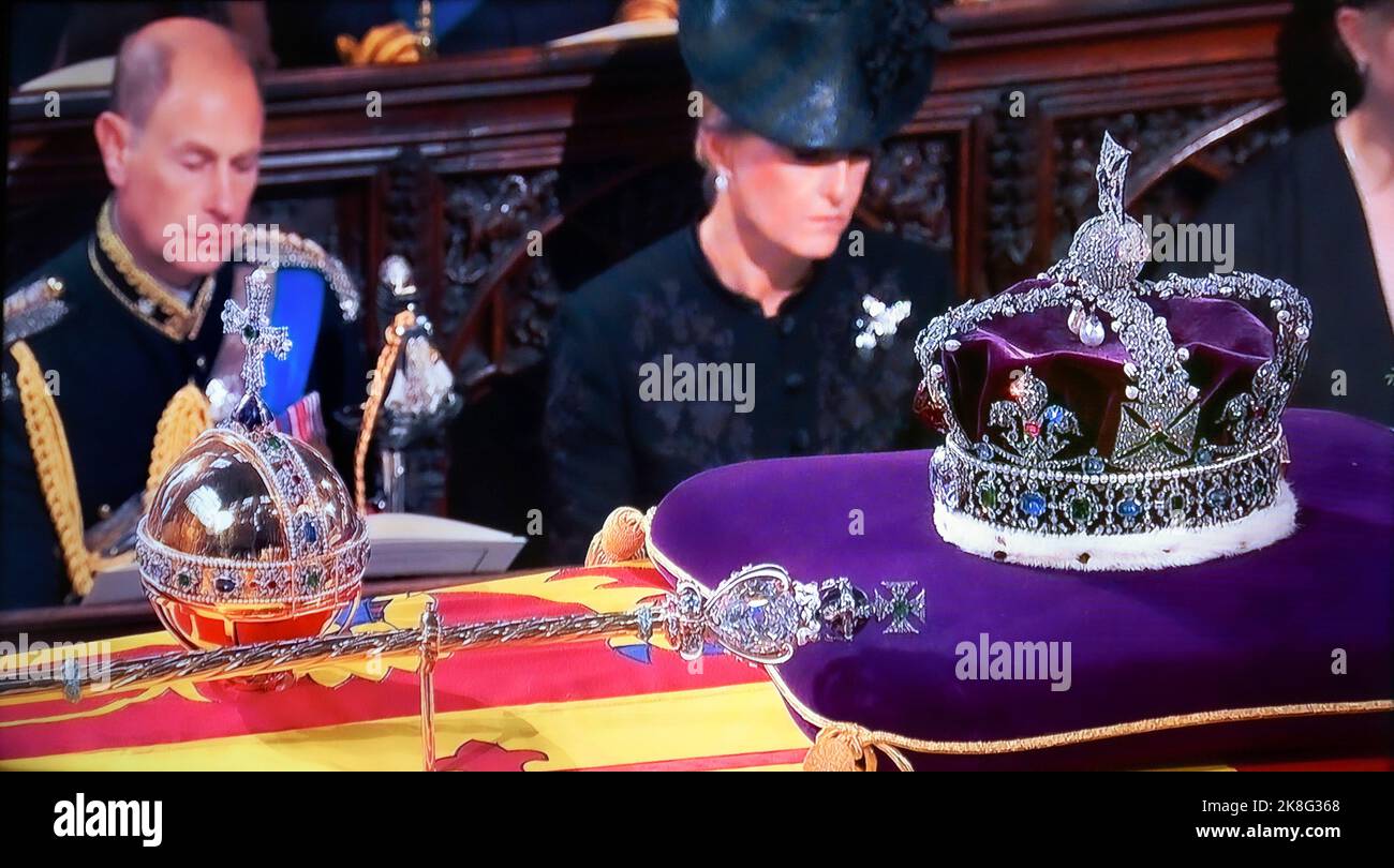 CROWN JEWELS Queen Elizabeth funeral service inside interior at St. George’s Chapel Windsor, with the Monarch’s Imperial State Crown, Sceptre and Orb on her Majesty’s coffin, the symbols of the British Sovereign displayed in the interior at the royal chapel during the funeral service. Behind a sombre Earl of Wessex Prince Edward and Sophie, Countess of Wessex,  UHD Broadcast still. 19/09/2022  St. Georges Chapel Windsor Berkshire UK Stock Photo