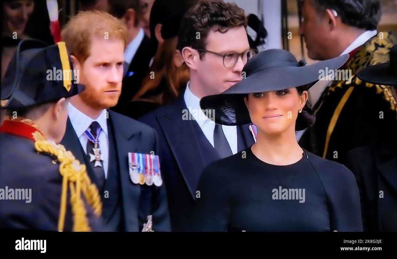 HARRY & MEGHAN The Duke and Duchess of Sussex at the funeral of Queen Elizabeth II departing St Georges Chapel Windsor Castle Berkshire UK A serious Prince Harry and a smiling Meghan Markle together on the steps of the Royal Chapel 19 Sep 2022 Stock Photo