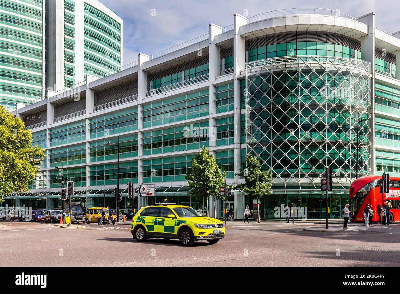A fast paced specialist emergency Ambulance vehicle racing to attend an accident driving past the University College Hospital London Stock Photo