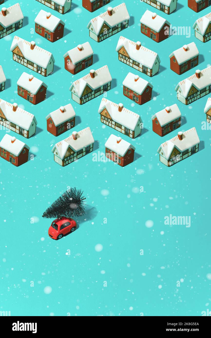 Trendy minimal pattern different snow-covered houses and a car with a Christmas tree on a pastel blue background. Concept of preparing for Christmas a Stock Photo
