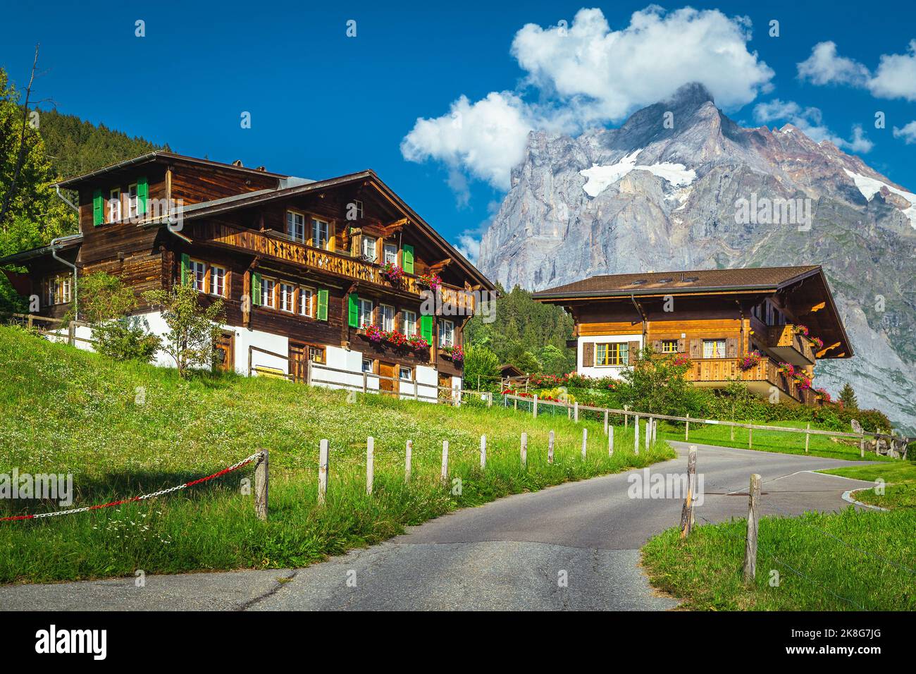 Wooden houses and flowery garden on the hill. Stunning view with high mountains, Grindelwald, Bernese Oberland, Switzerland, Europe Stock Photo