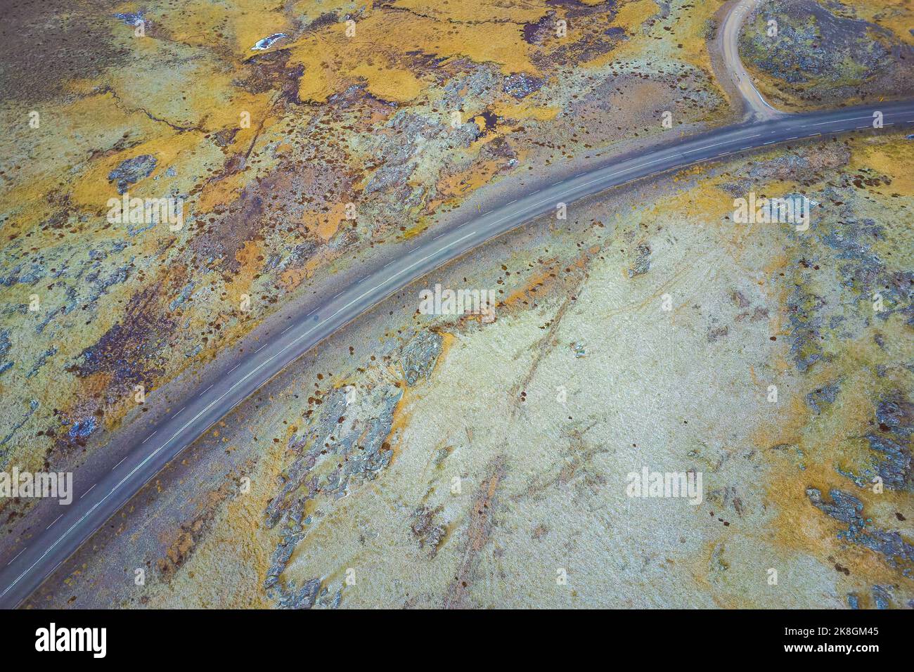 Aerial top view of curvy asphalt road going through valley on summer ...