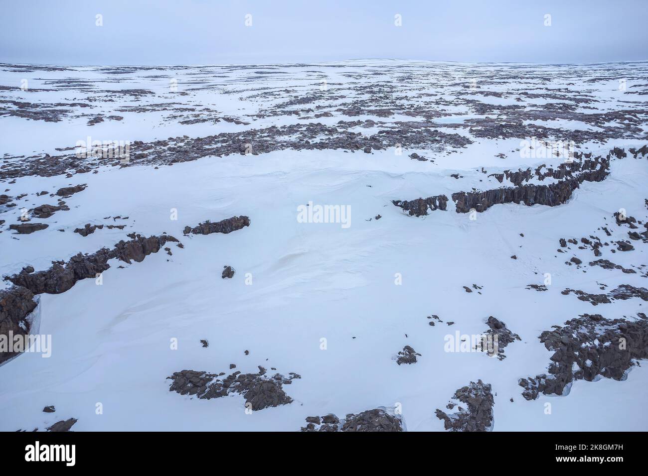 Aerial top view of rough stone formations covered with white snow on ...