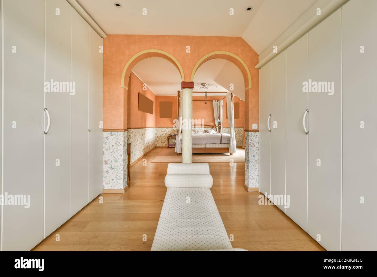 Soft ottoman placed on floor near white closet and cabinet in light ...