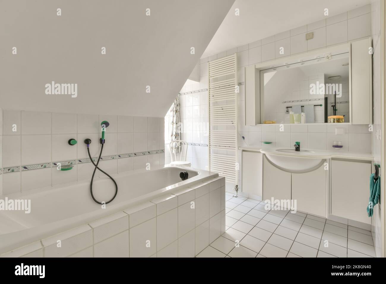 white ceramic bathtub placed near window and sink in spacious white