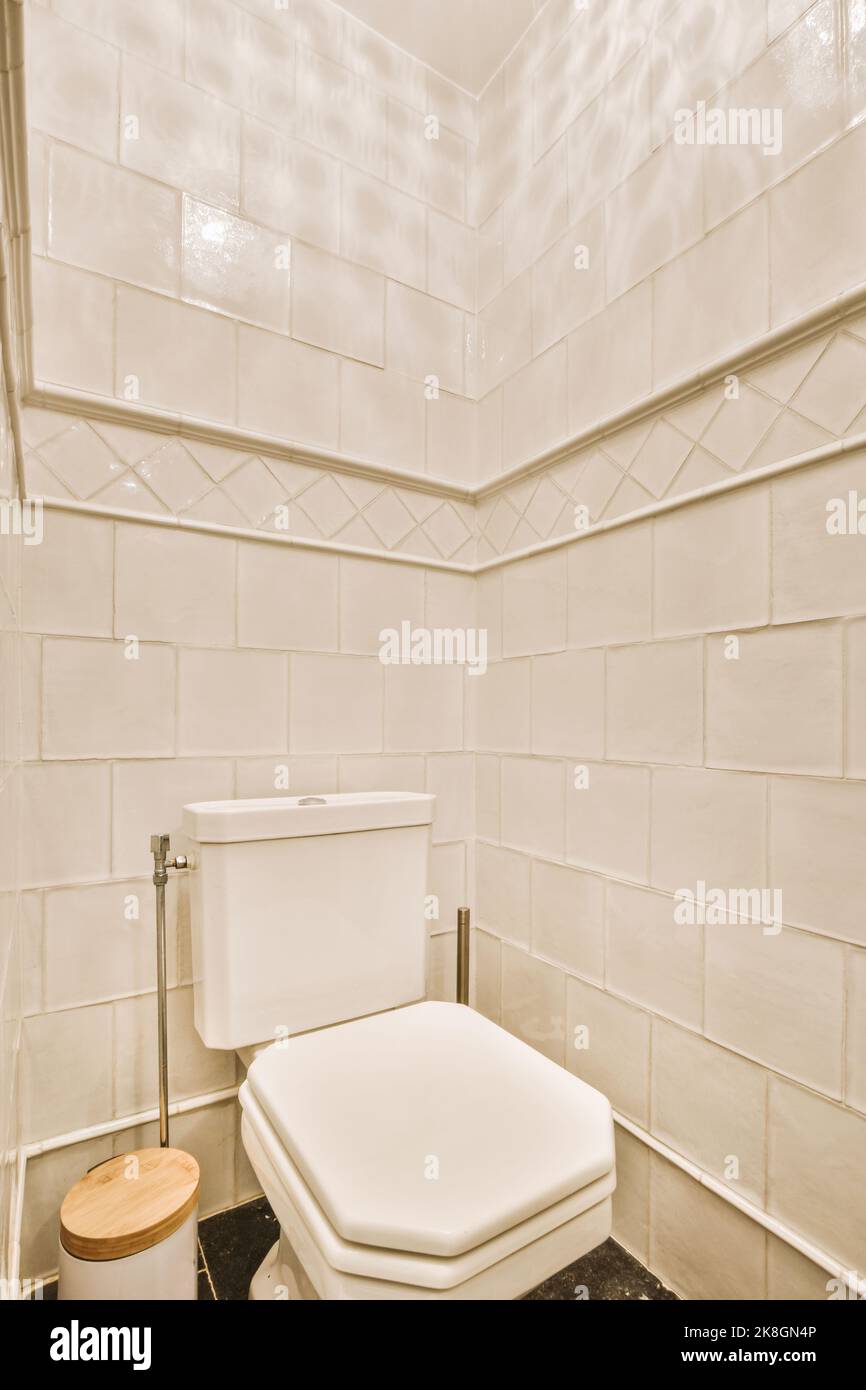 Modern toilet installed on beige wall under button and illuminated