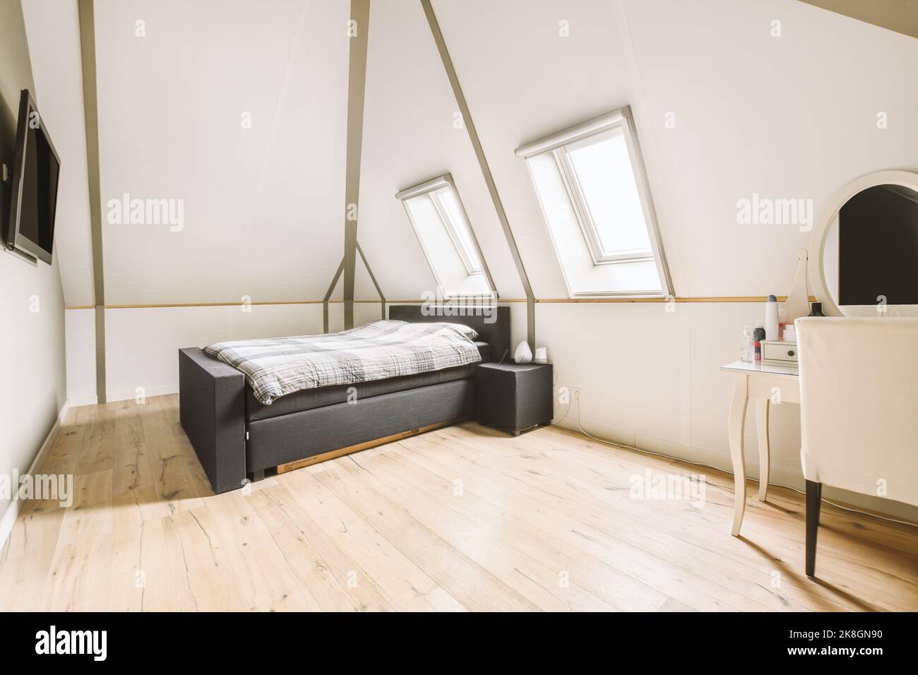 Interior of bedroom located in attic of house with tv on the wall in ...