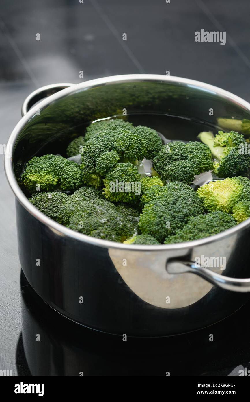 Boiling broccoli vegetable on an induction cooktop. Closeup Stock