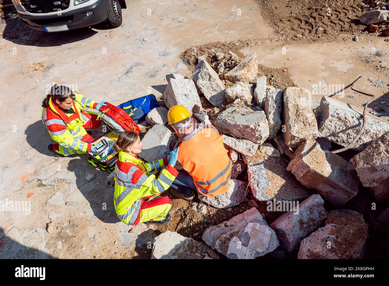 Emergency doctor and paramedic taking care of man on site of accident Stock Photo