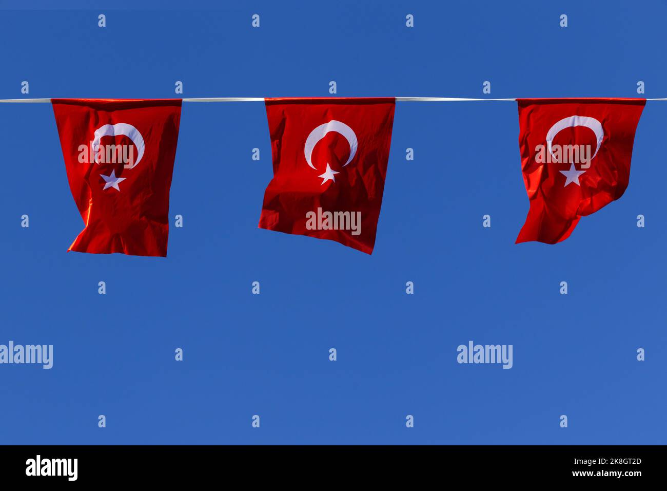 Many red Turkish flags isolated at sunny blue sky background. Horizontal color photography Stock Photo