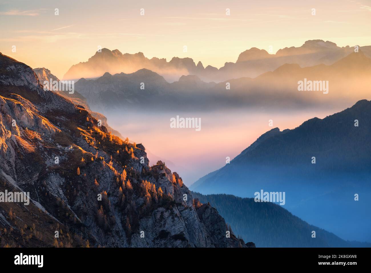 Mountains in low clouds at beautiful sunset in autumn in Italy Stock Photo