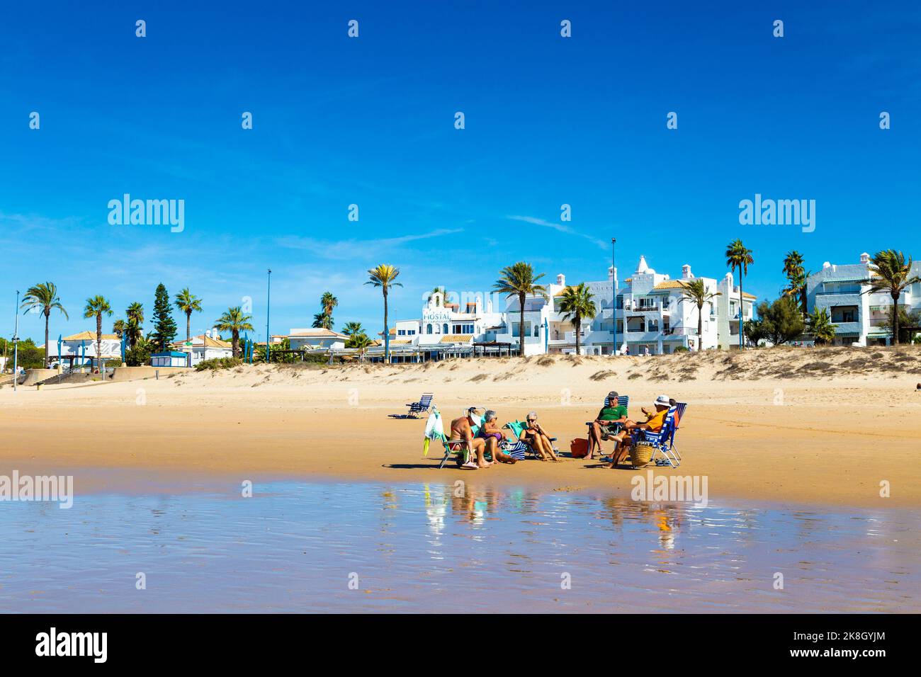 People relaxing and sun bathing at Playa de la Barrosa, Cadiz, Spain Stock Photo
