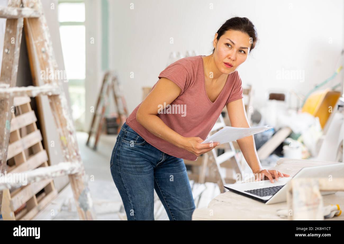Woman designer using laptop in construction site Stock Photo