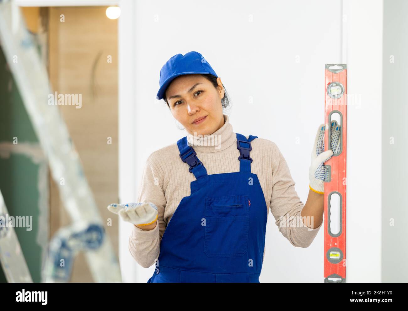 Builders Using Measure Woman builder using building level measures the vertical of wall Stock ...