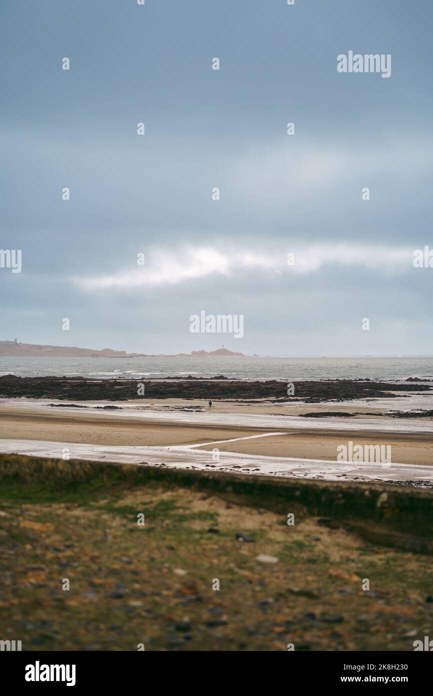 The view of La Corbière Lighthouse in Jersey from Le Braye beach. Channel Isands Stock Photo