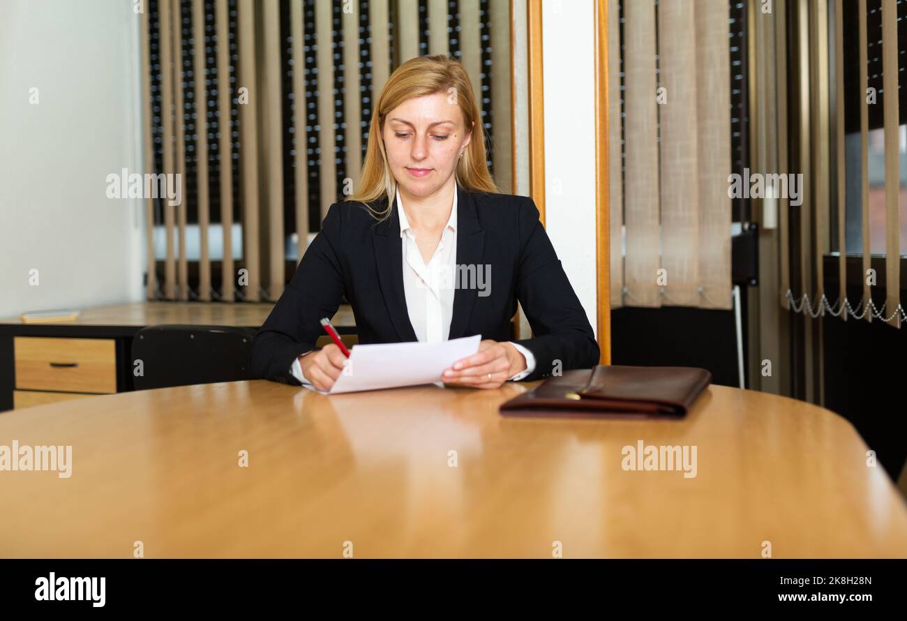 Business woman in office interior filling up documents Stock Photo - Alamy