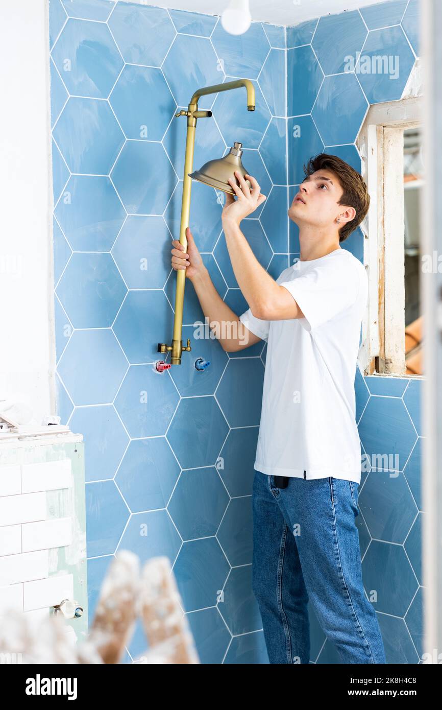 Guy preparing new shower for installation in building under construction Stock Photo
