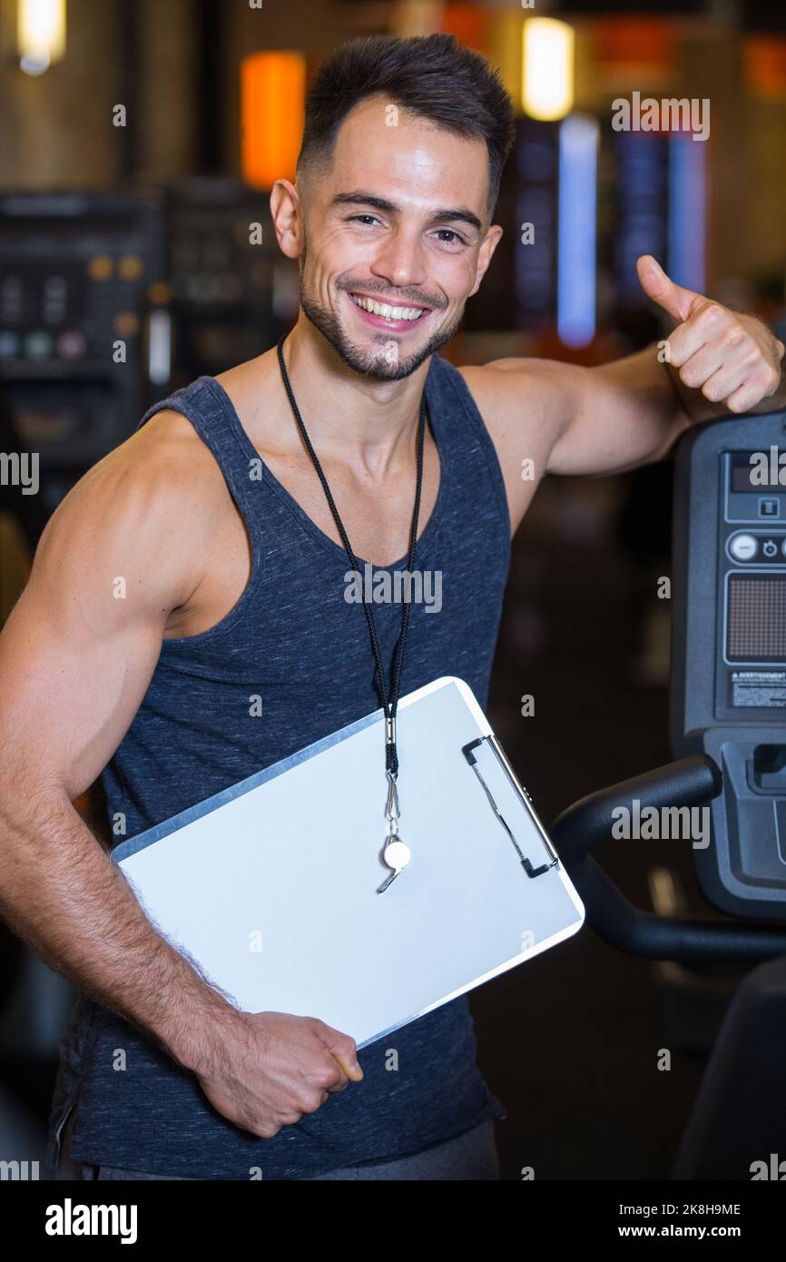 male personal trainer in a gym holding thumbs up Stock Photo Alamy