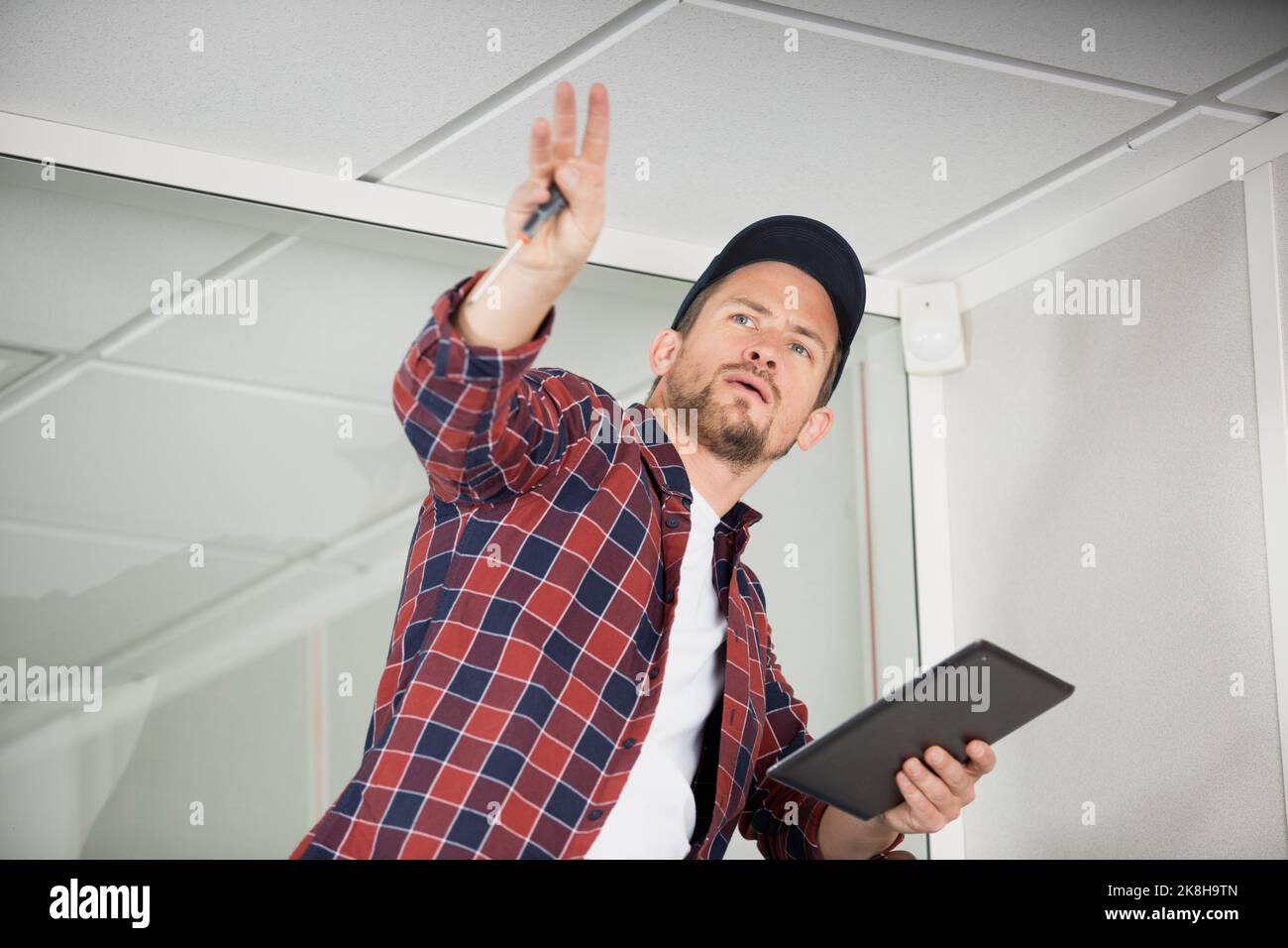 handsome foreman using digital tablet on a ladder Stock Photo
