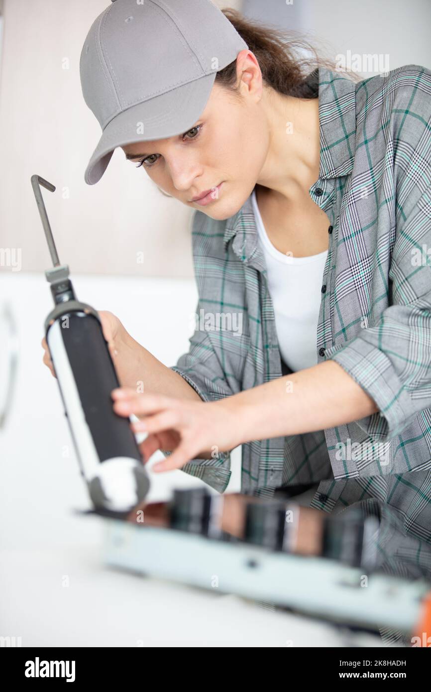 woman installing induction hobs in a kitchen Stock Photo