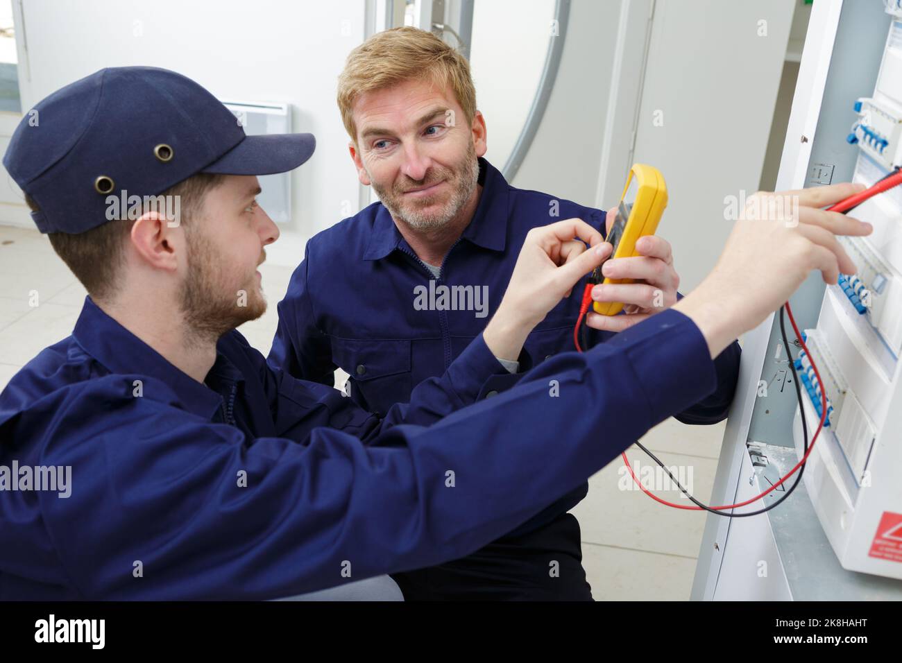 electrician measuring voltage in distribution board Stock Photo