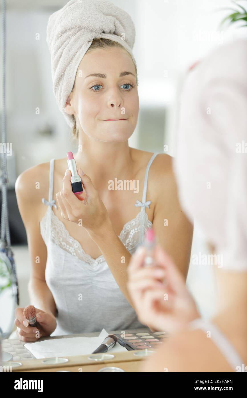 beautiful woman rubbing her lips together after applying lipstick Stock