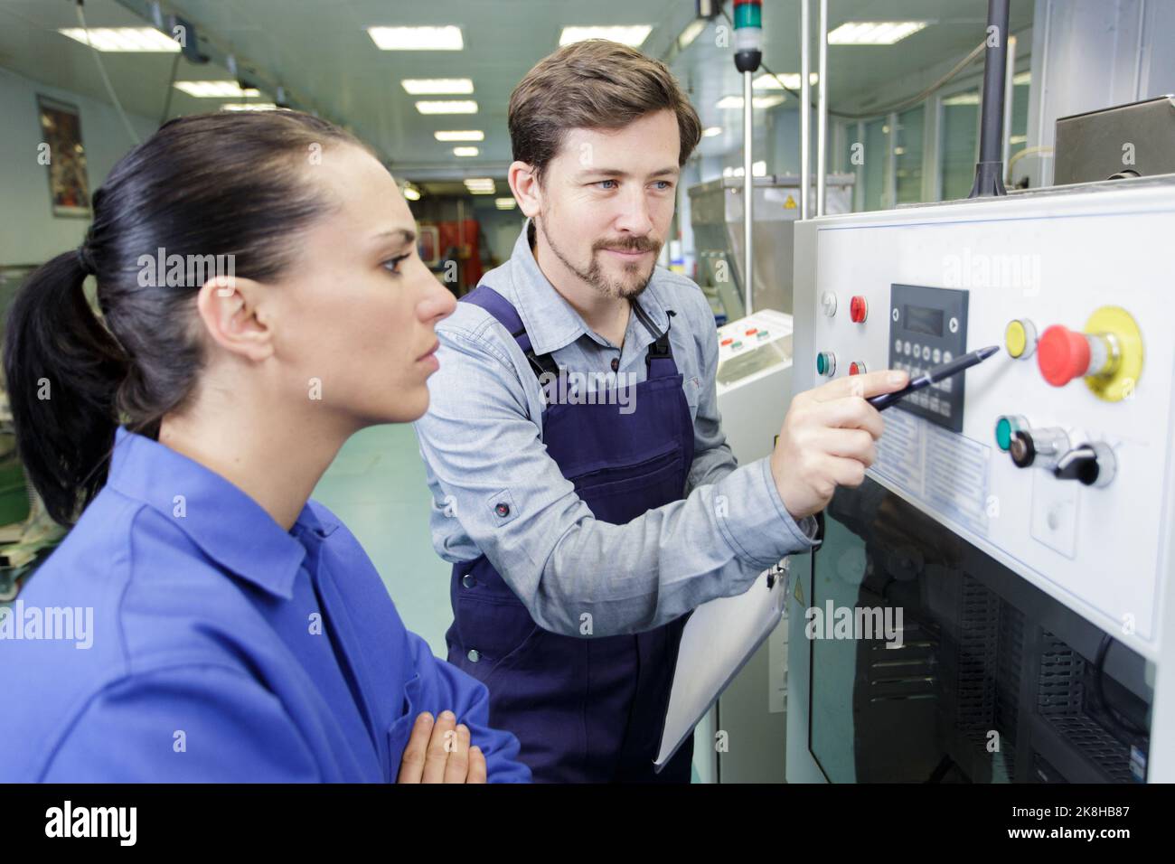 portrait of apprentice working with engineer on cnc machine Stock Photo