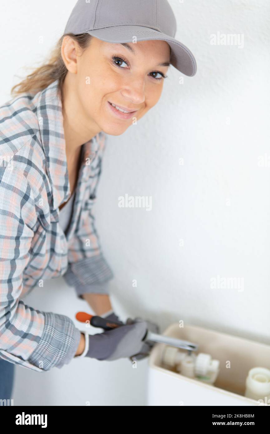 Female plumber installing a new toilet cistern stock photo alamy