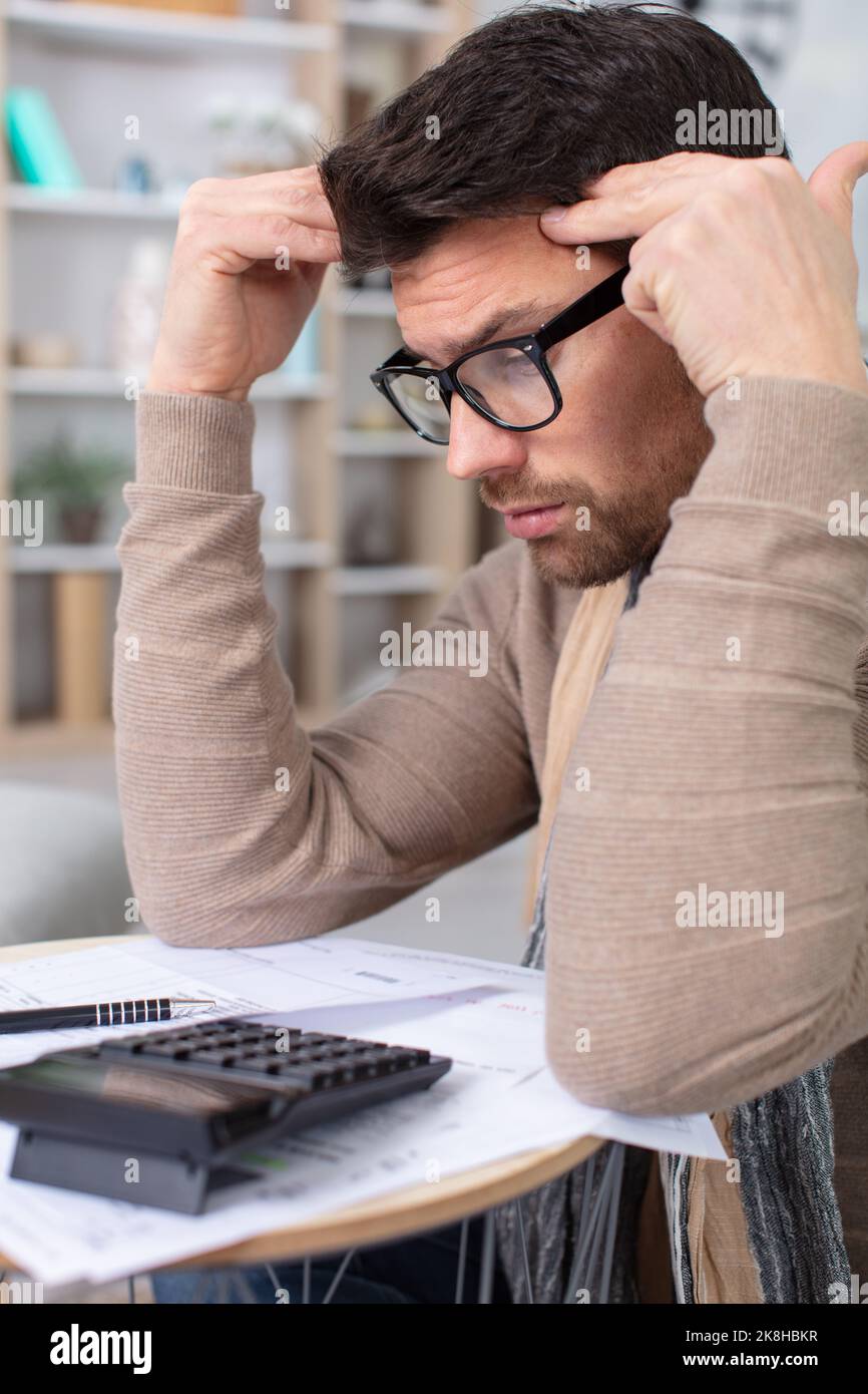 man troubled doing his home accounts Stock Photo