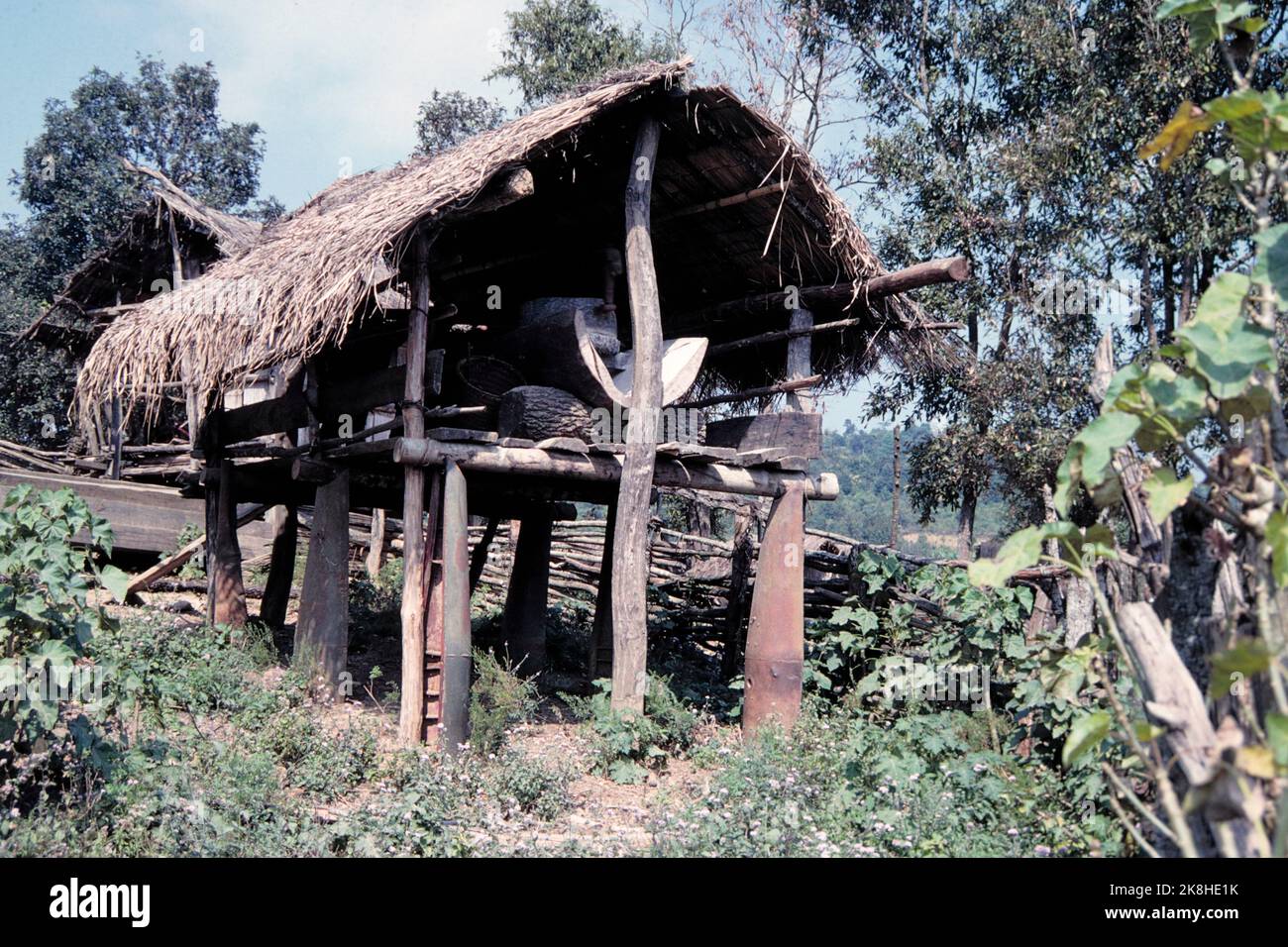 US-made cluster bomb casings put to practical use by Lao villagers as supports for rice storage huts, Plain of Jars, Laos 1997 Stock Photo