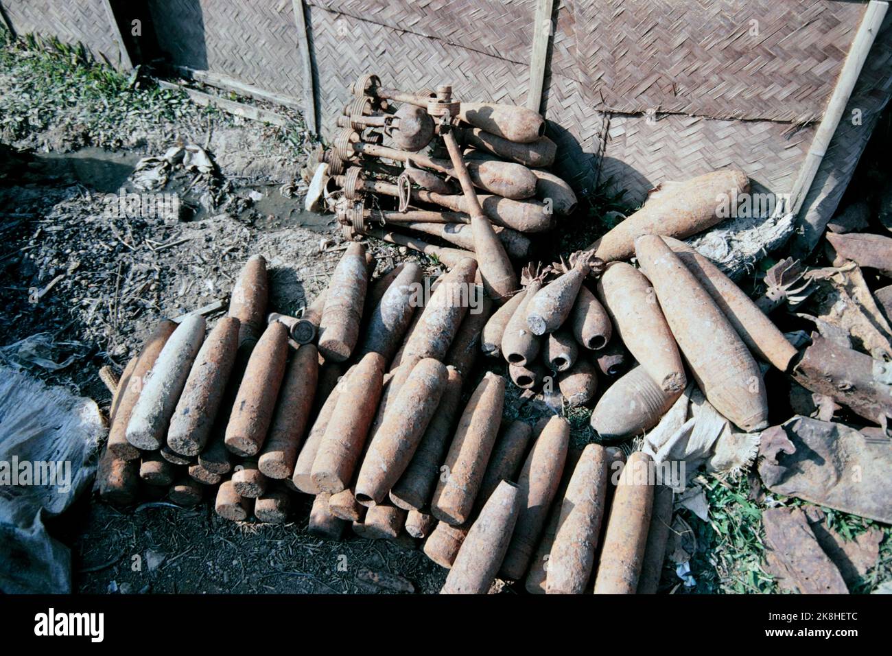 US-made cluster bomb casings collected and placed at roadside scrap yard, Plain of Jars, Laos 1997 Stock Photo